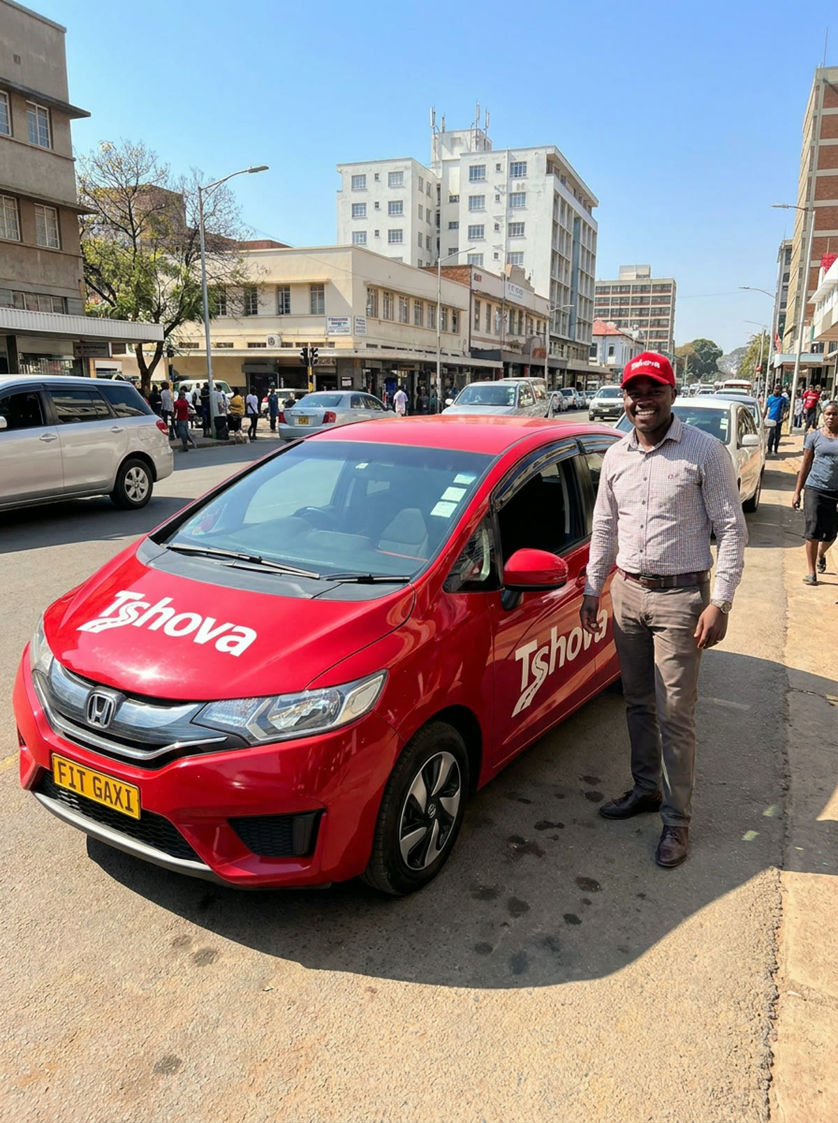 A Tshova driver beside his red Honda Fit on a Harare street